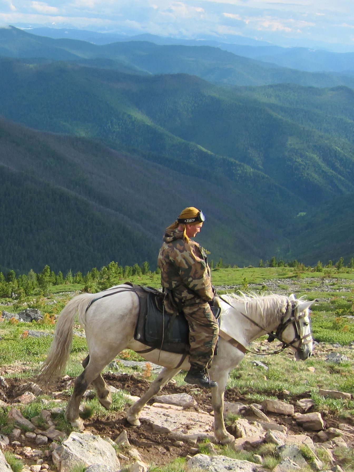Rider on a rocky summit overlooking mountain valleys